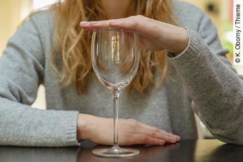 Frau hält Weinglas zu