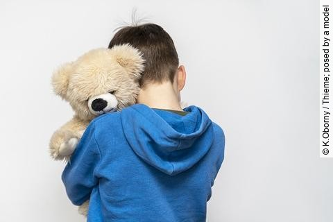 Ein Junge umarmt seinen Teddybär. 
