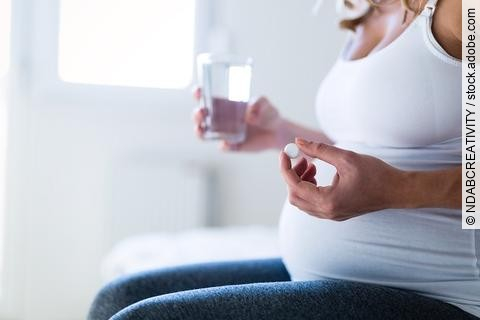 Schwangere Frau nimmt Nahrungsergänzung ein.