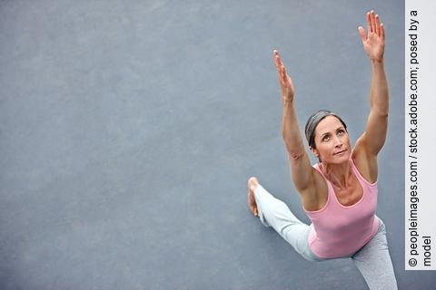 Frau macht draußen Yoga, Krieger 1