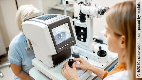 Augenärztin kontrolliert das Auge einer Patientin durch ein Messgerät.