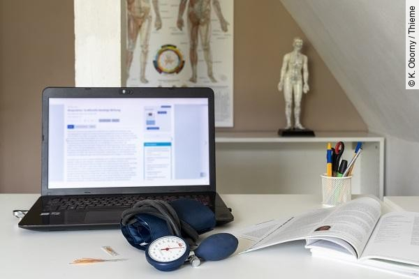Bildschirm, Akupunkturmodell, Stethoskop, Symbolbild für integrative Medizin