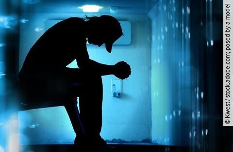 Silhouette eines Mannes vor blauem dunklen Hintergrund, Fatigue