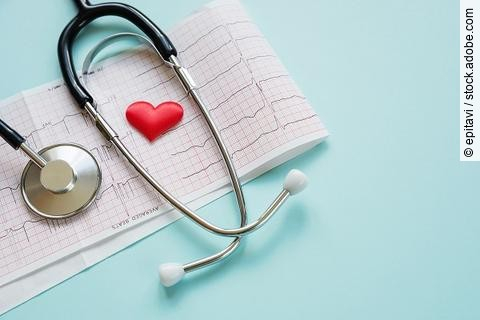 Ein Stethoskop und ein rotes Herz liegen auf einem ausgedruckten Kardiogramm.